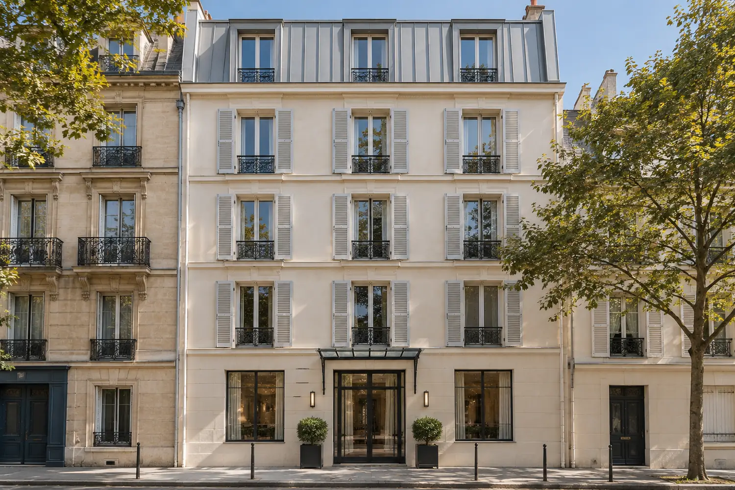 Immeuble parisien de cinq niveaux transformé en petit hôtel, entrée vitrée sous marquise, vu depuis la rue